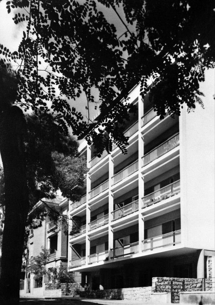 Black-and-white photograph of a rectangular, white-walled modernist building, five storeys high